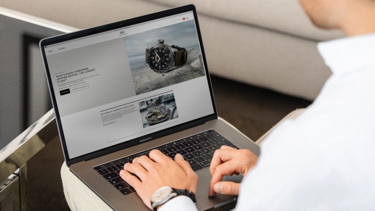 Man working in laptop with screen displaying an IWC webpage