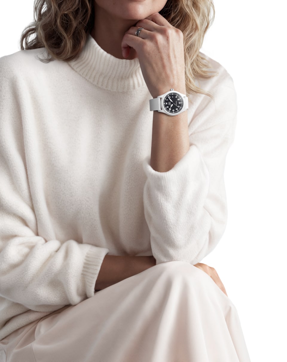 A woman with a white outifit wearing the Pilot’s Watch Automatic 41 TOP GUN Lake Tahoe with white case and strap, and black dial