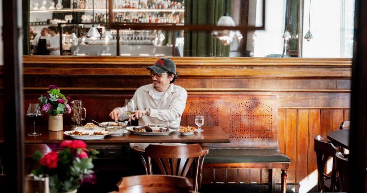 Pascal Grob sitting at a full table at Gallo Bistro in Geneva