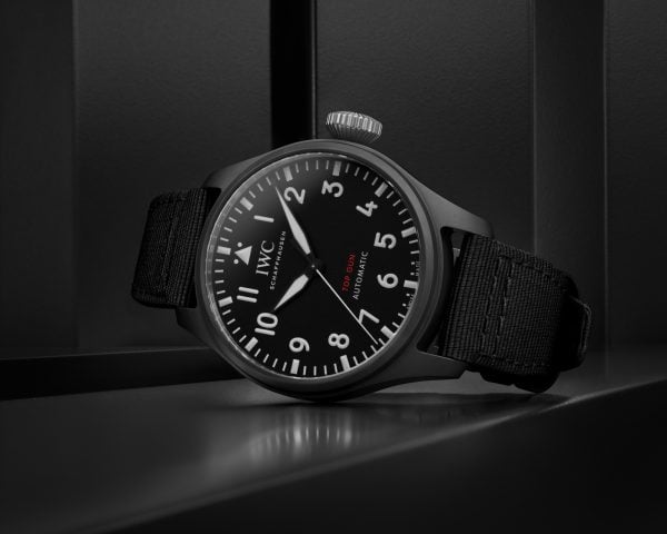 Front image of a black dial watch with a black textile strap