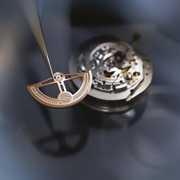 An IWC Watchmaker applying the final parts for a caliber